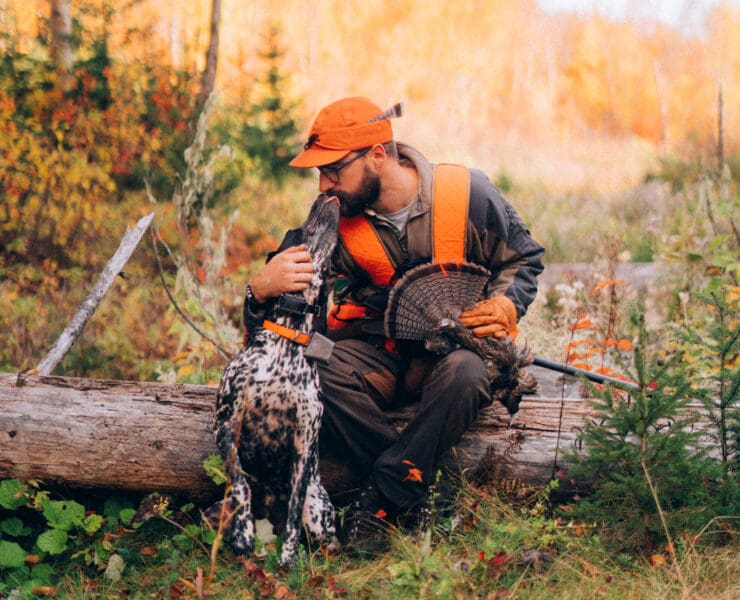 A bird hunter in Maine with his pointing dog while ruffed grouse hunting.