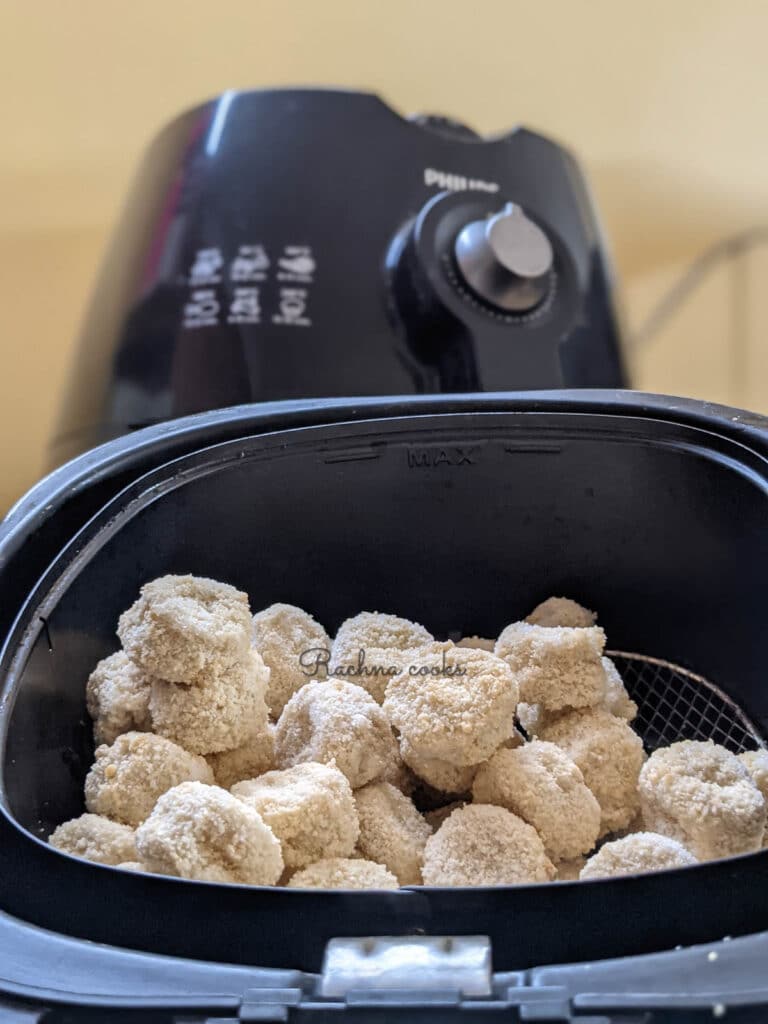 frozen popcorn chicken placed in air fryer basket ready to go into air fryer