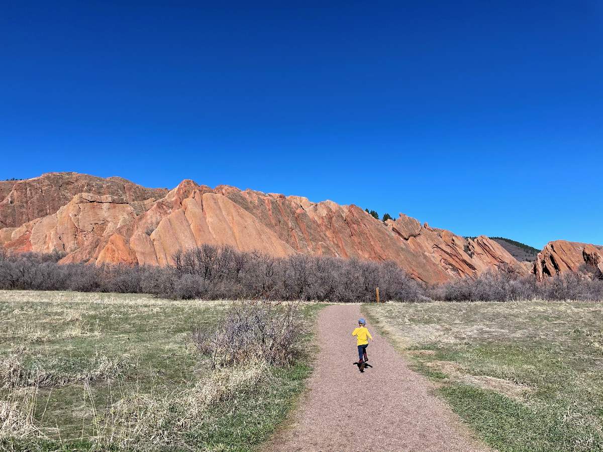 boy running on trail with red rocks