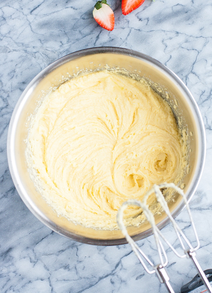 mixing bowl with strawberry cream cheese muffin ingredients mixed together with an electric mixer