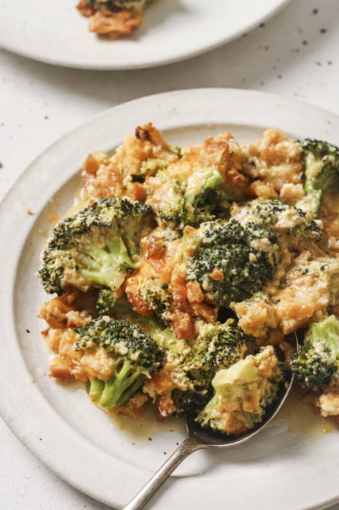 A plate of broccoli casserole with a spoon.