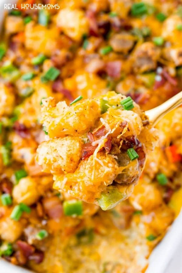 Spoonful of Tater Tot Breakfast Casserole being taken out of the baking dish