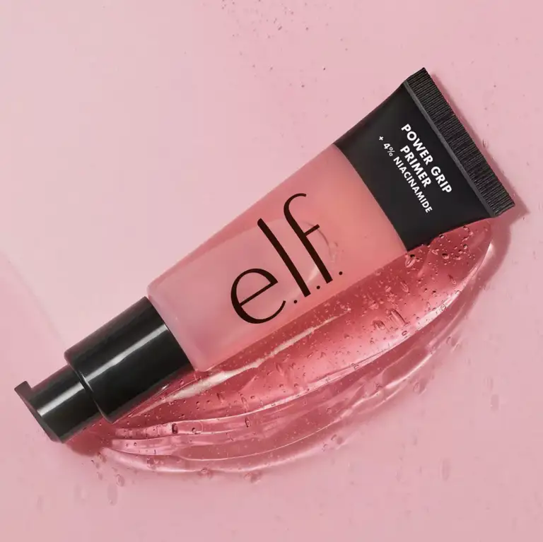 a tube of elf power grip primer is sitting on a pink surface