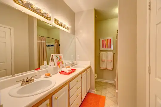 bathroom featuring tile flooring, double sink vanity, shower curtain, and mirror