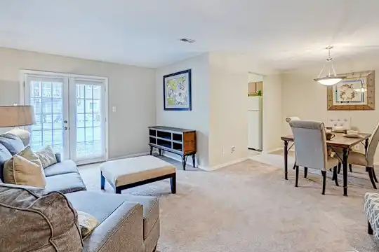 carpeted living room featuring french doors and refrigerator