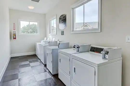 clothes washing area with tile flooring, plenty of natural light, and separate washer and dryer