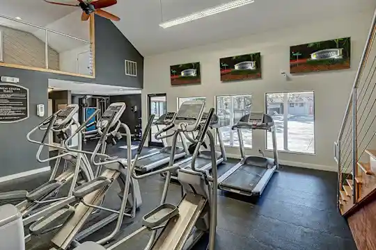 workout area with a ceiling fan and TV