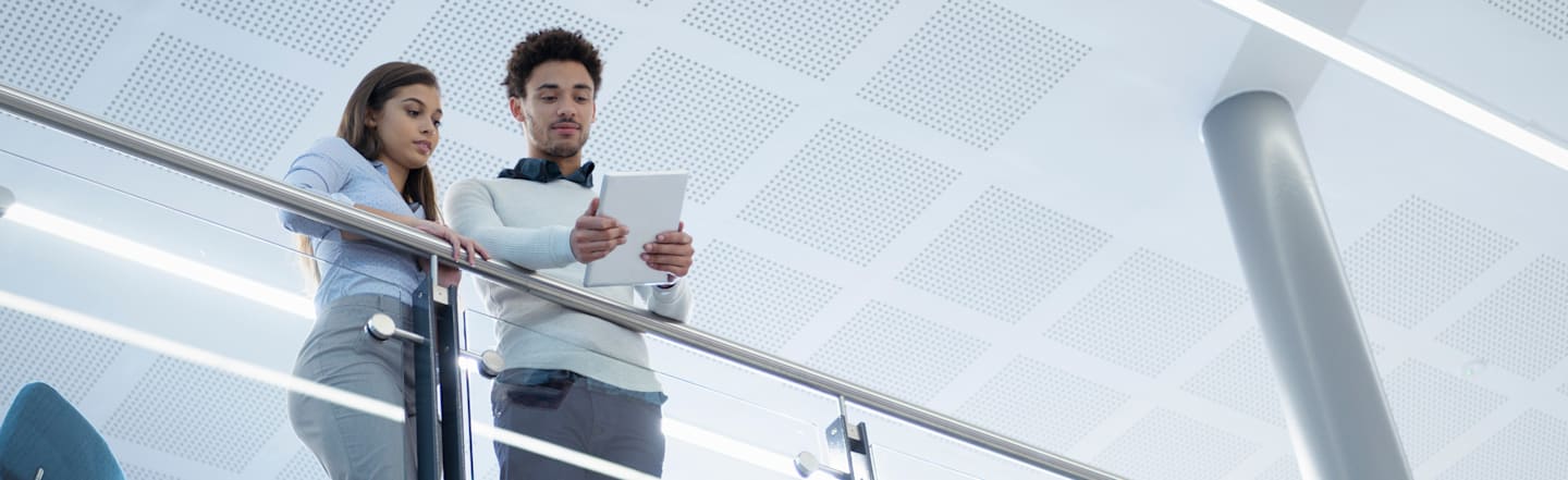 Two interns looking at a tablet.