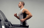 Free Stock Photo: A healthy young man running on a treadmill in a gym