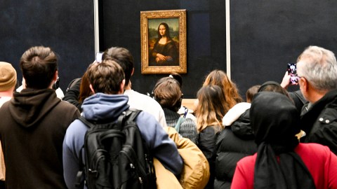 People crowd around the Mona Lisa at the Louvre.