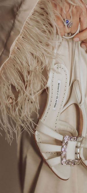 Sparkly buckle on white Manolo Blahnik designer wedding shoes for bride