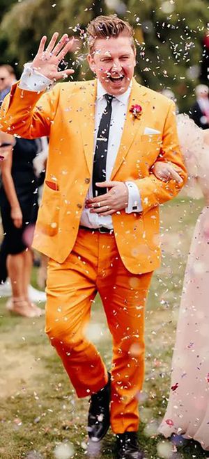 groom wearing colourful, unique mustard orange groom on wedding day