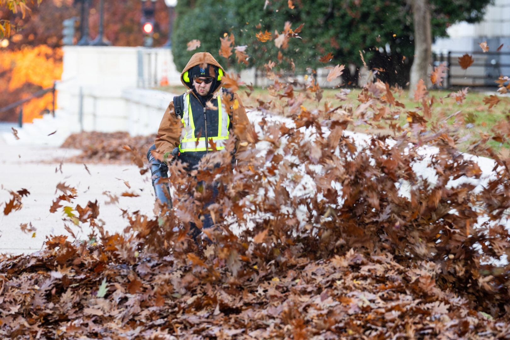 A worker  clears leaves from the sidewalk along Constitution Avenue in front of the Russell Senate Office Building on Monday ahead of Congress' return. 