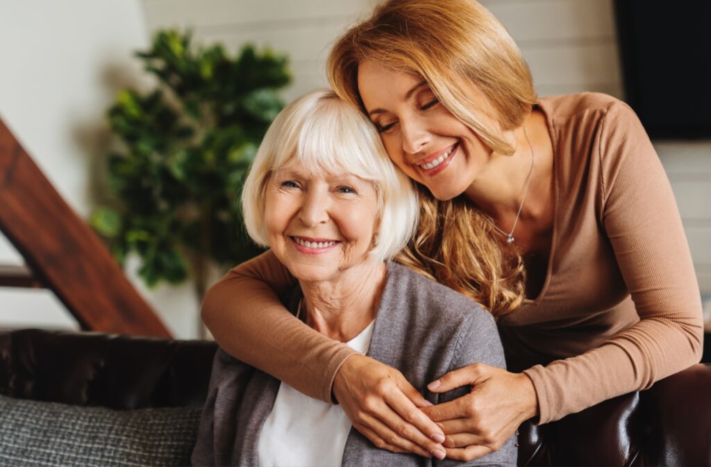 A daughter happily embraces her mature mother while visiting her in memory ca