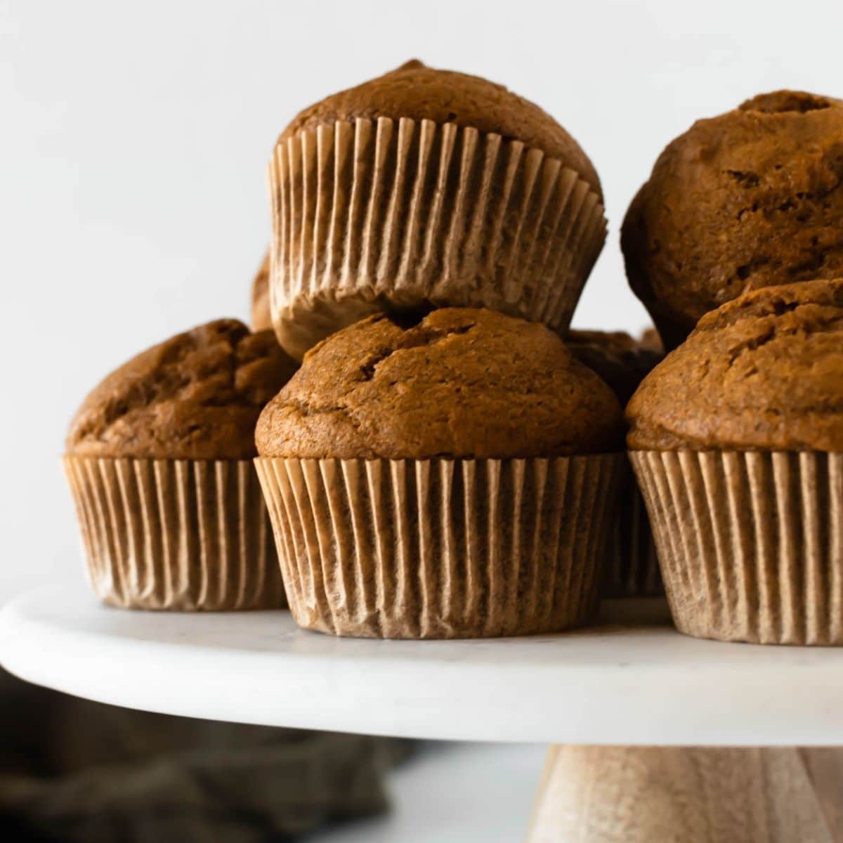 stacked pumpkin muffins on a cake stand.