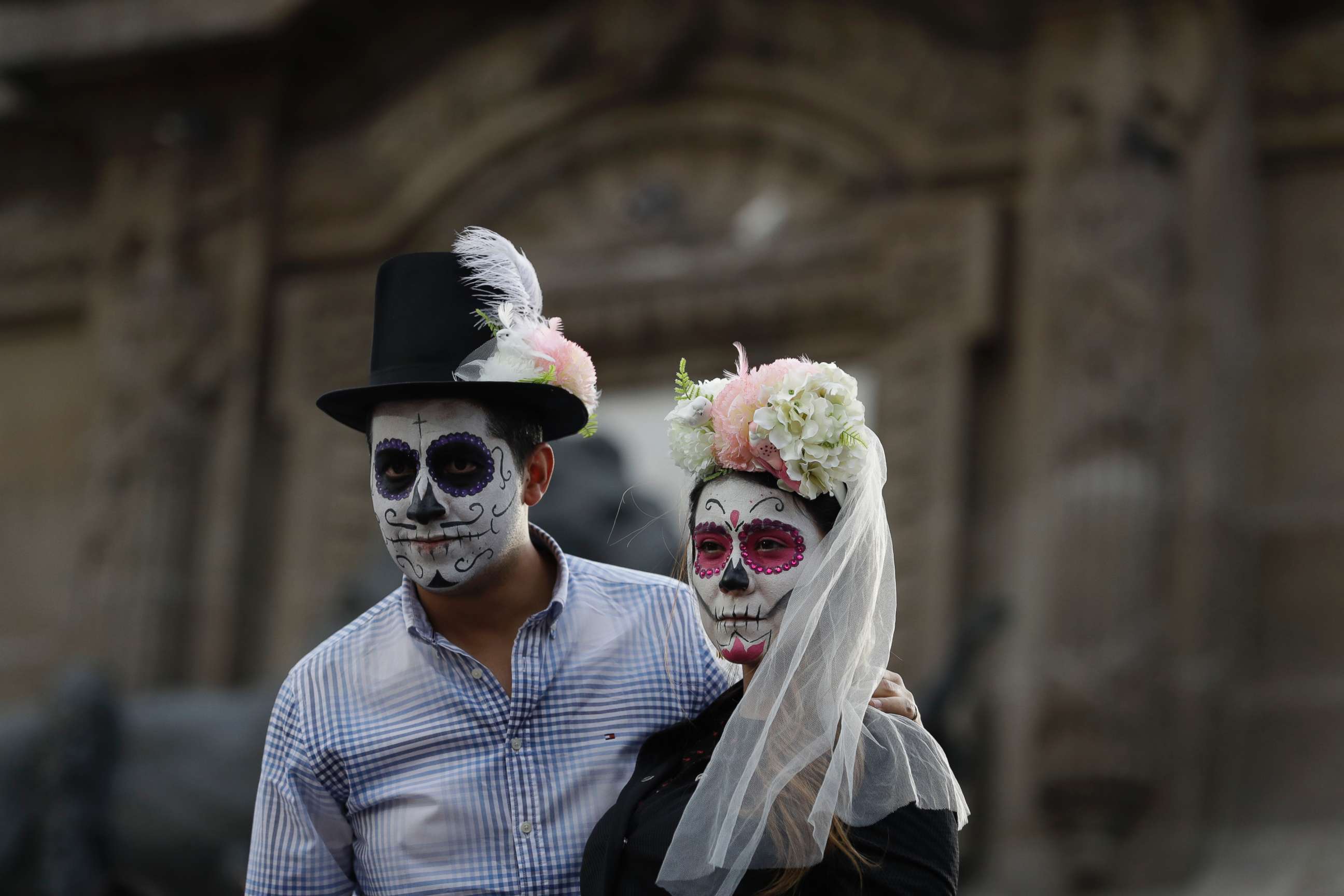 PHOTO: People dressed as a skeleton couple await the start of the Grand Procession of the "Catrinas," part of upcoming Day of the Dead celebrations in Mexico City, Oct. 22, 2017.