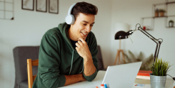 Homem usando fones de ouvido no escritório em frente o notebook