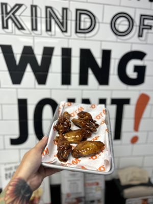 Photo of Wing It On! - Waterbury, CT, US. a hand holding a tray of wings