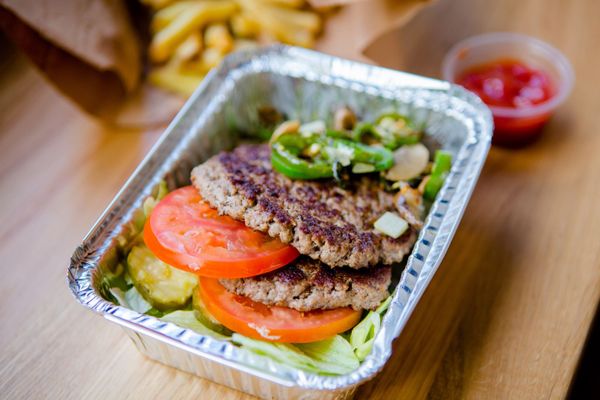 Photo of Five Guys - New York, NY, US. A photograph of the contents of a Five Guys burger bowl, which include two ground beef patties, tomatoes, jalapenos, lettuce ...