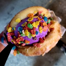 Photo of Stuffed Ice Cream - New York, NY, United States. White chocolate lavender ice cream in a donut with fruity pebbles