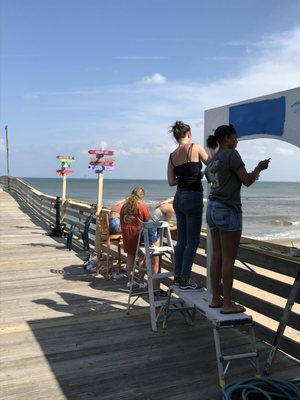 Photo of Virginia Beach Fishing Pier - Virginia Beach, VA, US. Sign painters giving us directions to lots of fun places