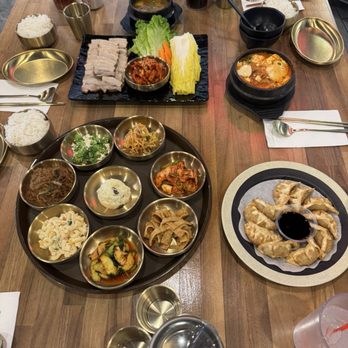 Bossam, banchan, fried dumplings, and sundubu-jjigae