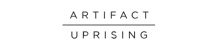 Artifact Uprising logo. Very thin typeface. All grey. The words ARTIFACT and UPRISING are stacked above one another with a thin grey line between them.