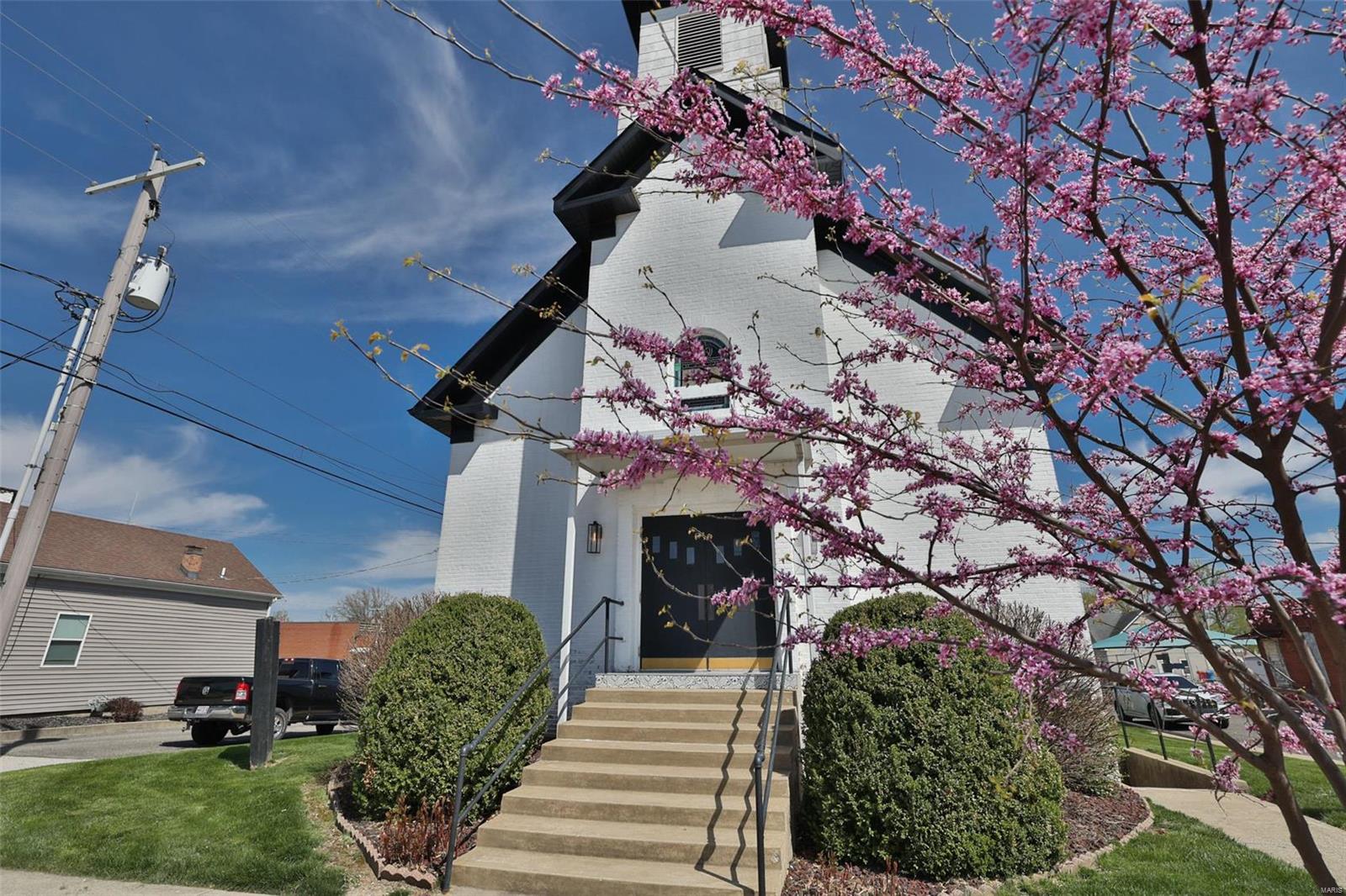 Nestled in the bustling heart of Troy, IL, this 1870s chapel is a sight to behold. As one of the city's oldest structures, its unique and timeless architecture has made it a local landmark. The ext features masonry & ornate stained glass windows. The bell tower stands tall & the structure is surrounded by a luscious lawn. Inside, the sanctuary is filled with light & air, thanks to the vaulted ship-lap ceilings, original hardwood floors, & beautiful stained glass windows.It has a long & storied history, having been the site of many important events in the city's past. It has served as a community gathering place for many generations. The church was newly ADA compliant with access. & 2 baths, an enclosed lift to all 3 levels & had been fully renovated in early 2020.In the lower level there are 3 private rooms and 2 small storage areas. Don’t wait to get started transforming this historic structure into the business of your dreams. Current bus in operation. Priced to sell.  Agent Owned