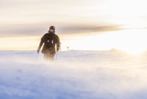 a skier with blowing snow in foreground