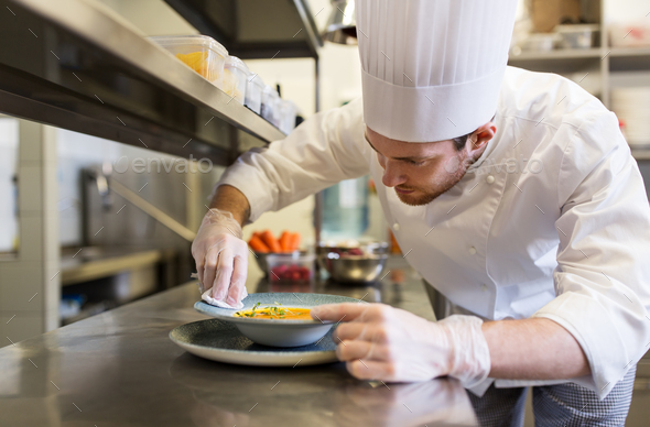 happy male chef cooking food at restaurant kitchen Stock Photo by dolgachov