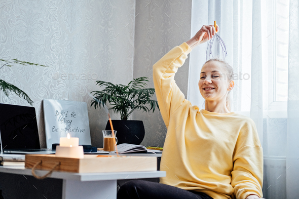 Woman on workplace with Head Massager Scalp Scratcher with Fingers. Self-massage with Head