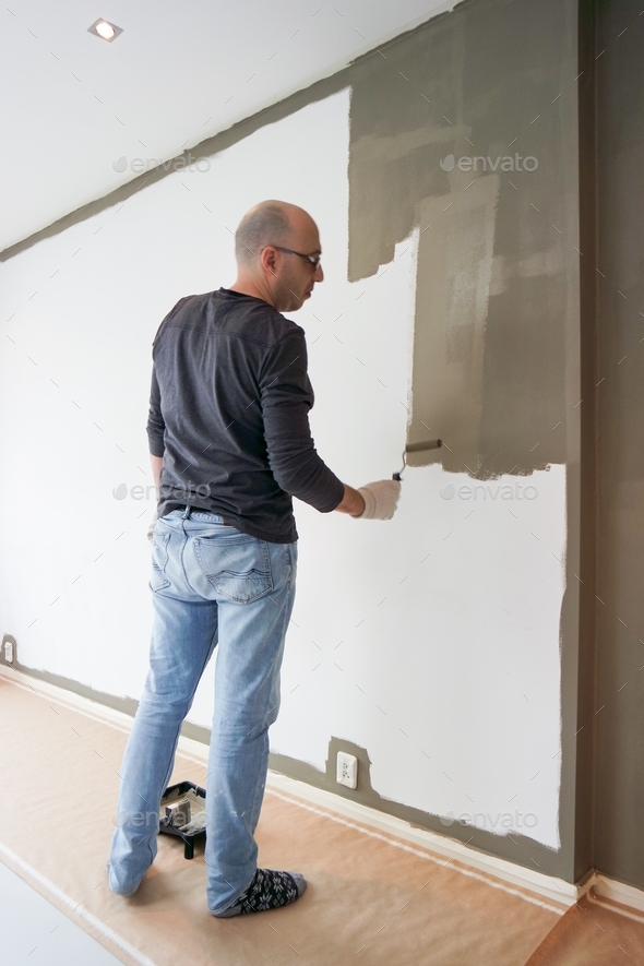 Man full length painting the wall in the living room. Stock Photo by ...