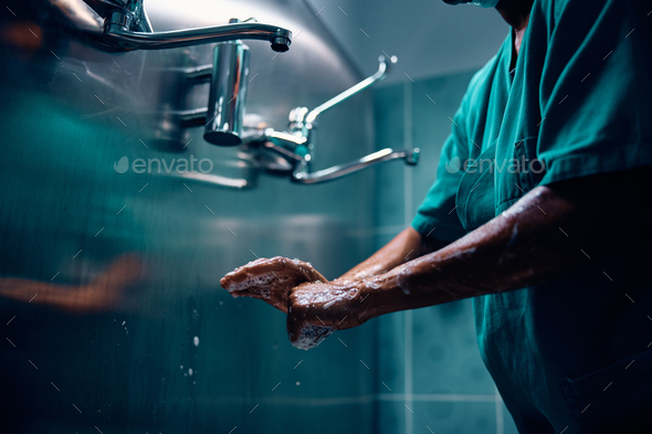 Close up of surgeon washing hands before getting into operating room ...