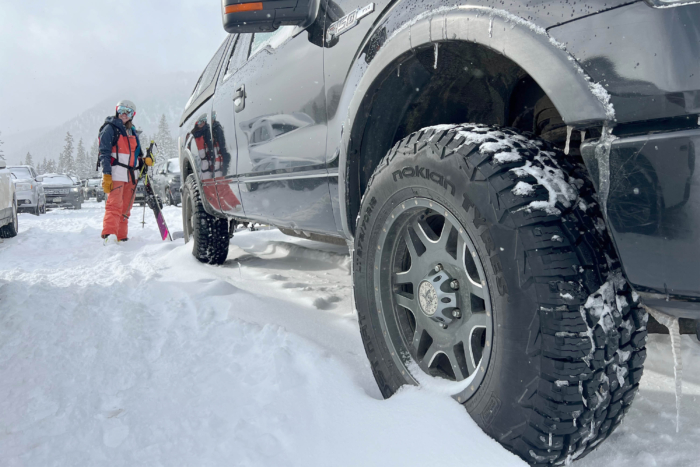 Nokian nAT tires and a skier on a snowy parking lot