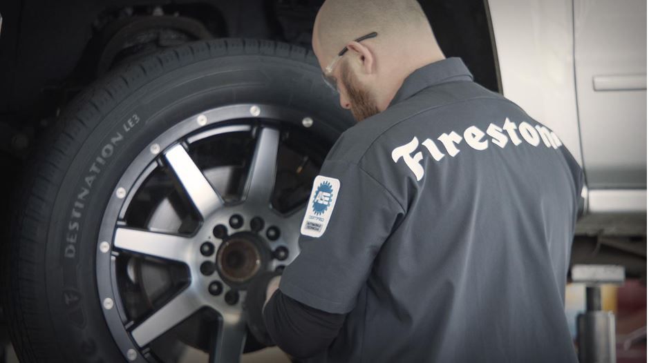 Firestone technician, Chris, observing a Destination LE3 tire in shop