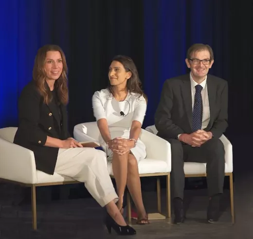 Panel discussion at event with three speakers on stage talking