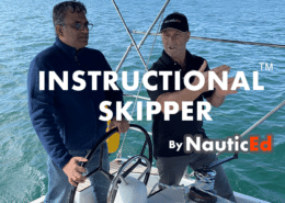 Two men discussing sailing techniques on a sailboat, part of NauticEd's Instructional Skipper program.