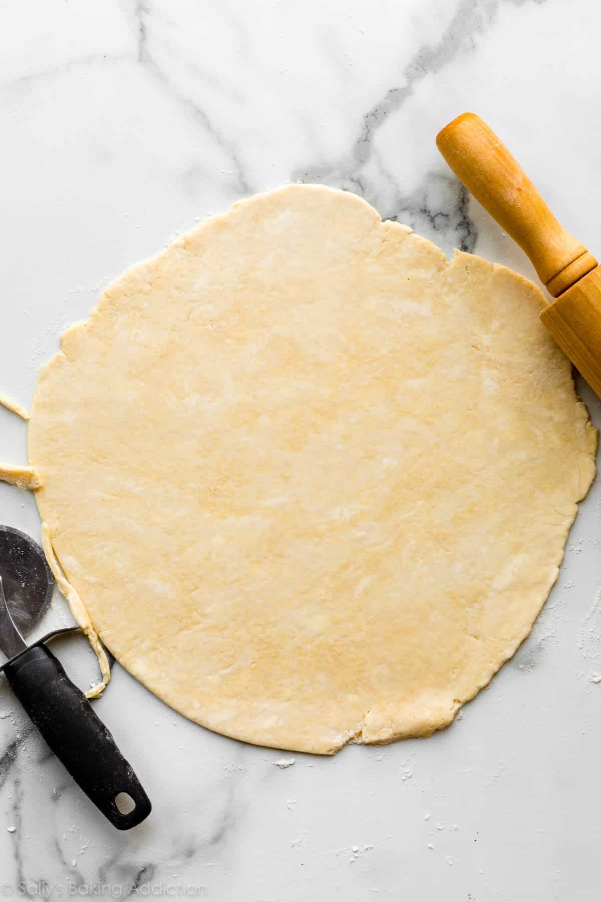 buttery pie dough rolled out on counter.