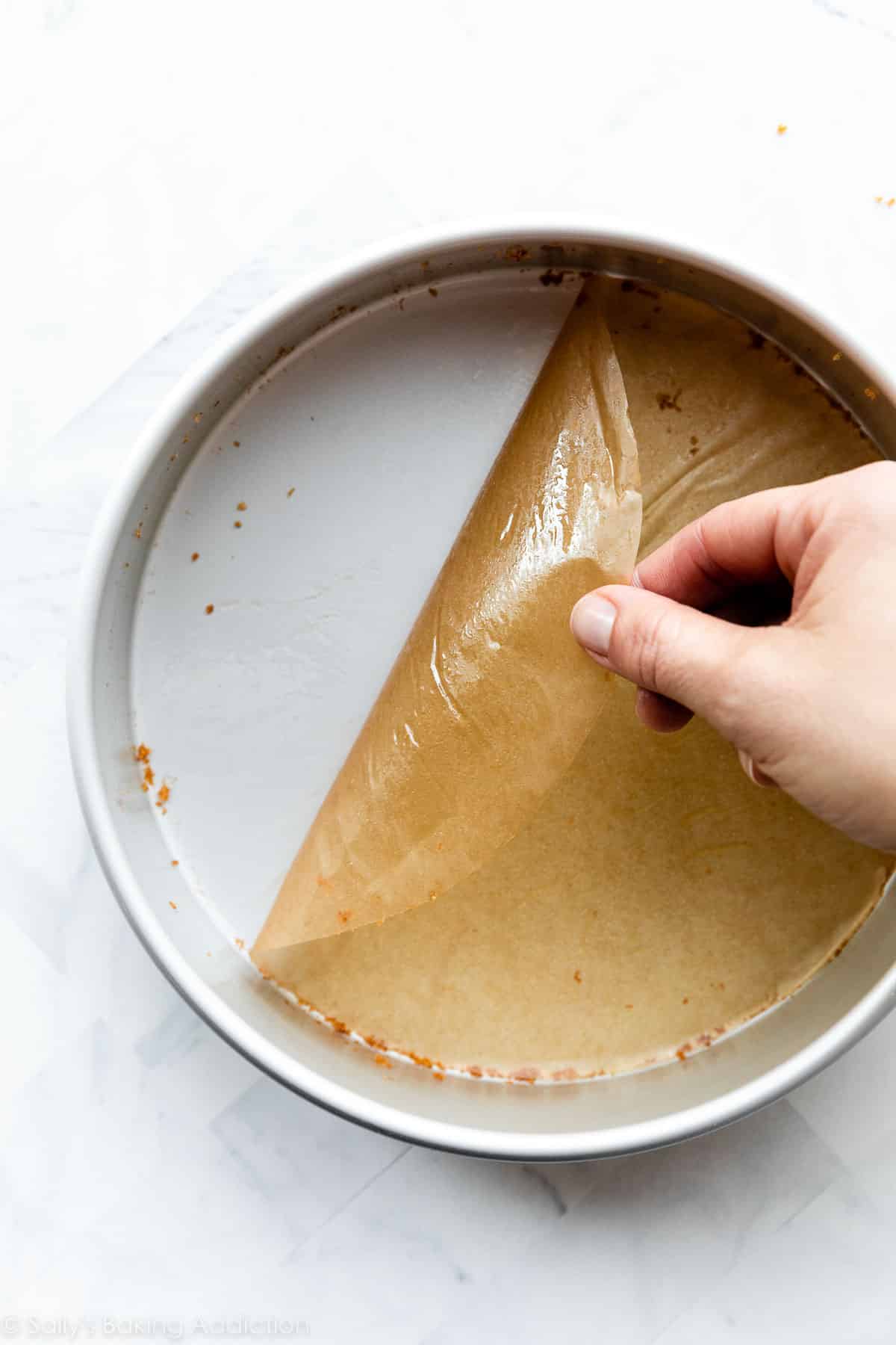 peeling parchment paper round off bottom of round cake pan.