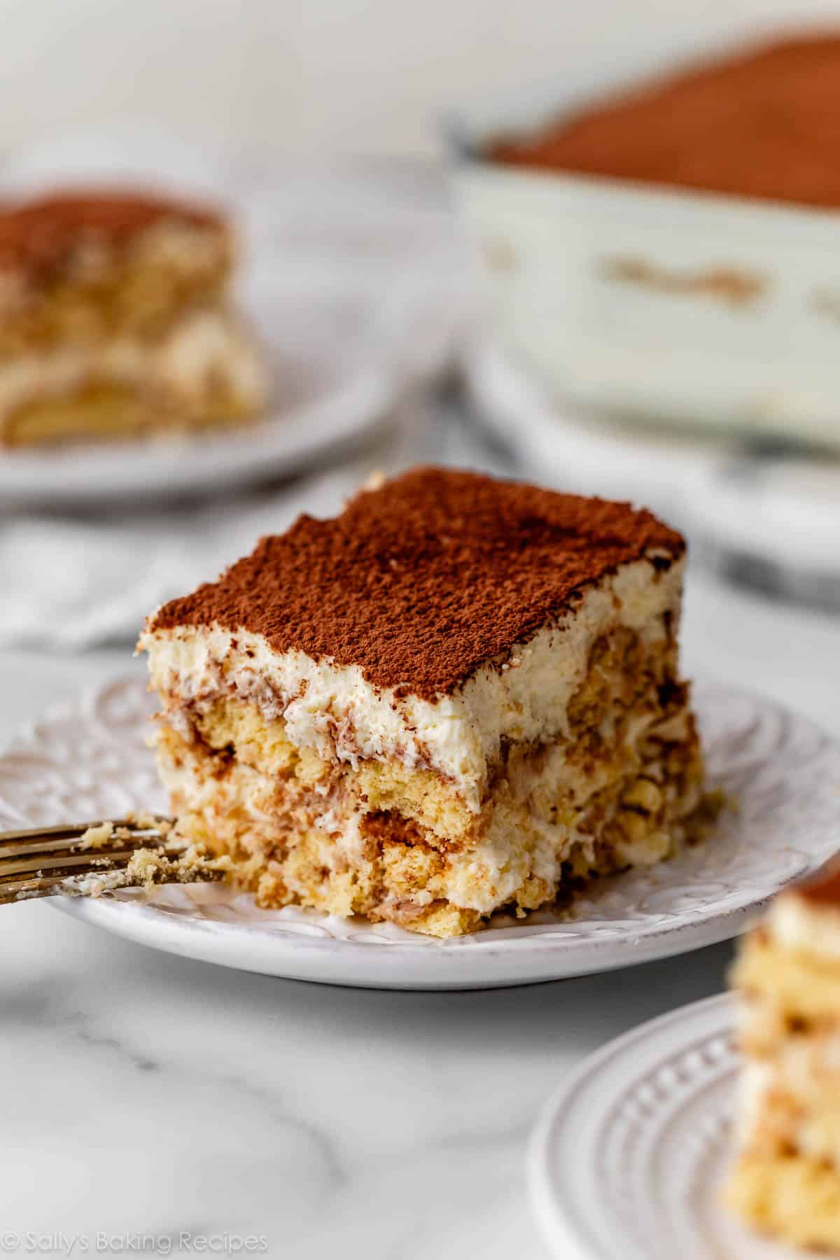 slices of tiramisu on white plates.