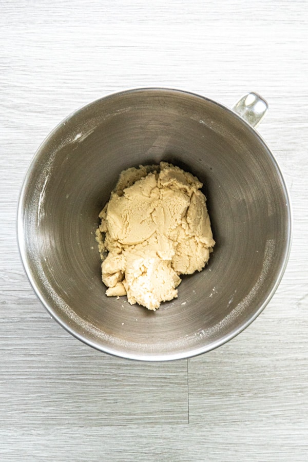 A stainless steel bowl with dough for the snowball cookie recipe with no nuts.