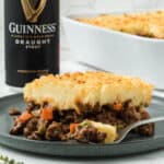 Guinness shepherd's pie on a grey plate with a can of Guinness in the background.