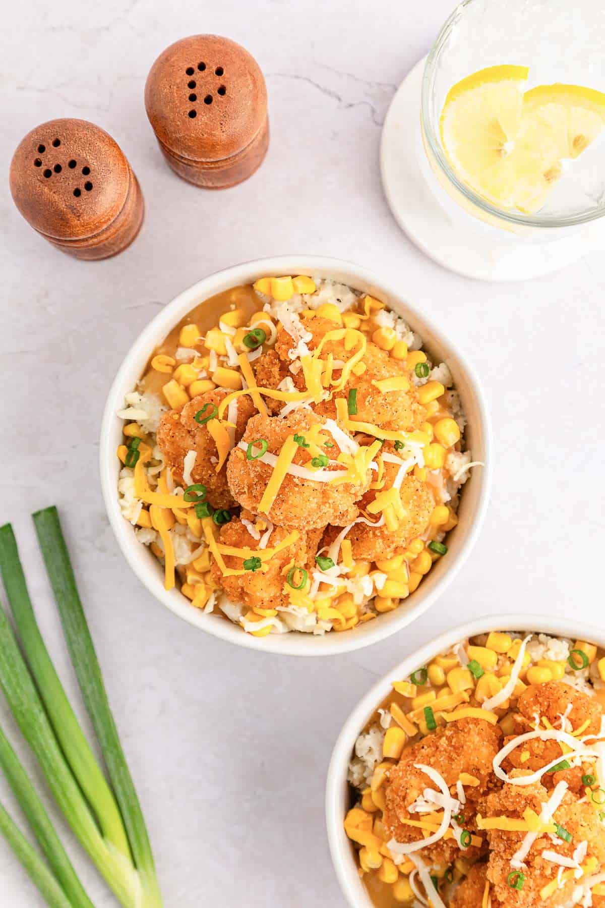 Copycat KFC famous bowl with popcorn chicken, green onions, and shredded cheese.