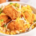 Homemade copycat KFC famous bowl topped with cheddar cheese and green onions.