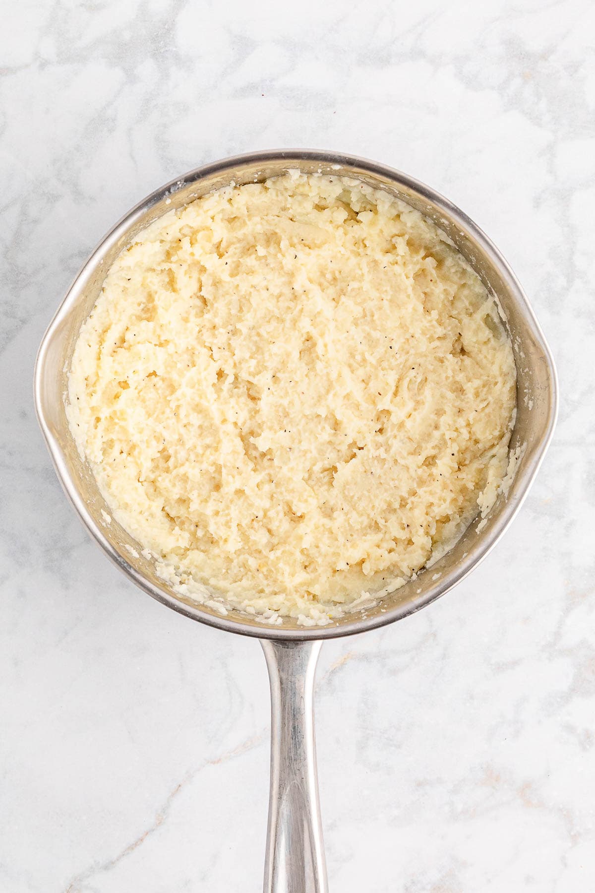 Prepared mashed potatoes in a stainless steel saucepan.