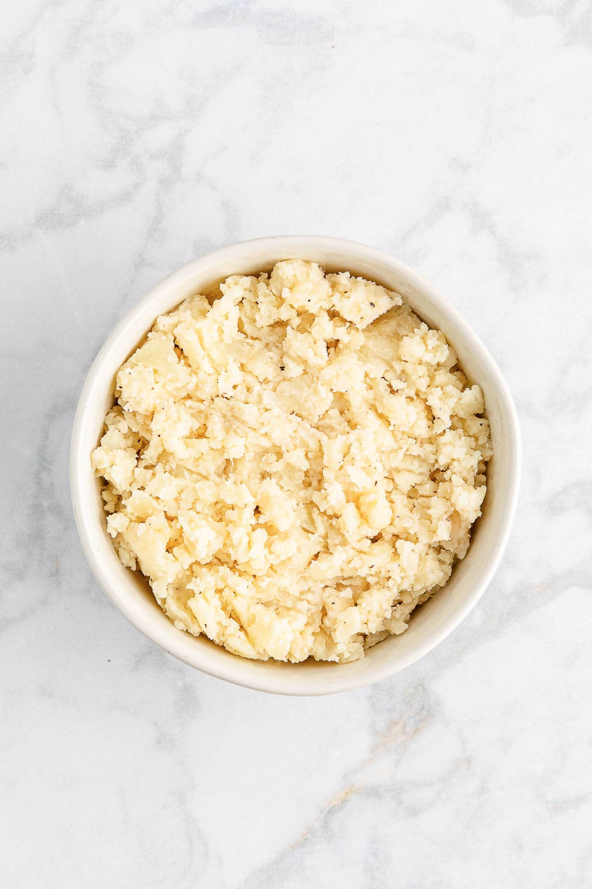 Mashed potatoes in a white bowl.