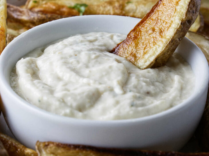 Dipping a French fry in aioli sauce.