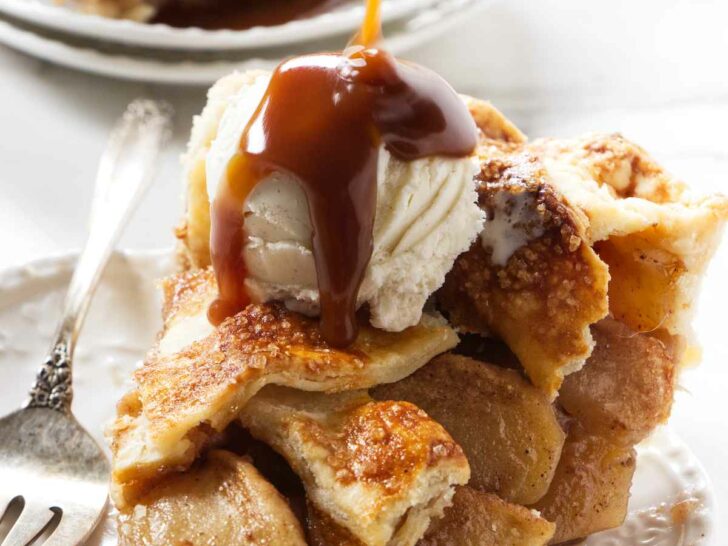 Drizzling caramel sauce over a scoop of ice cream on top of a slice of pie.