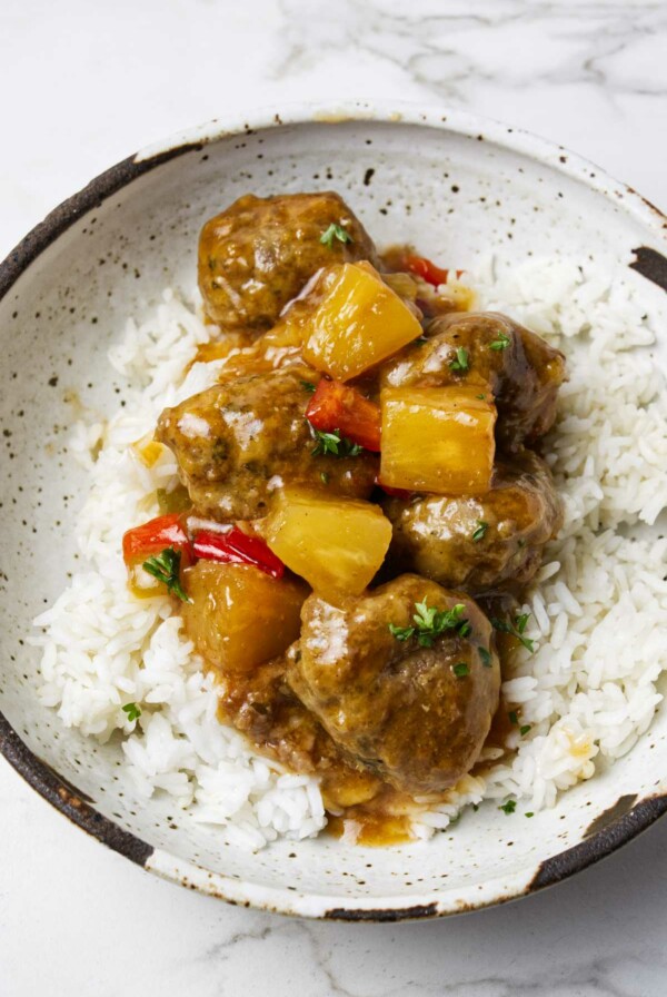 Sweet and sour meatballs on a pile of rice.