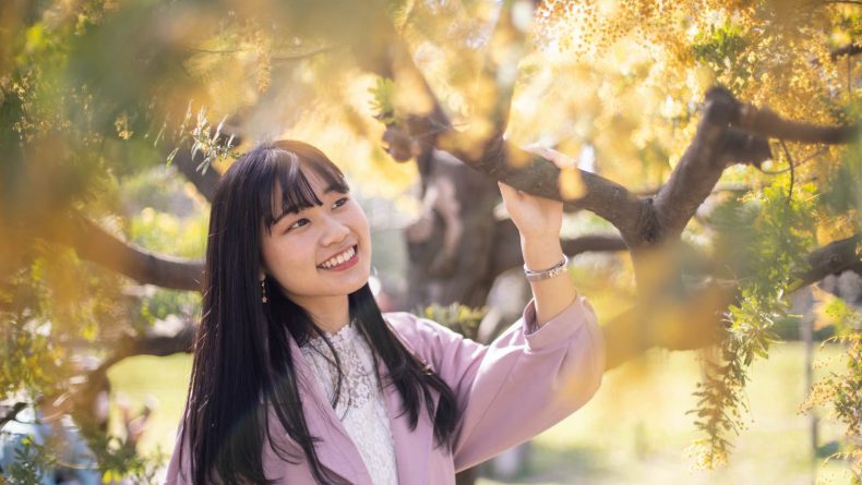 seasonal color palette young woman dressed in pink under fall leaves